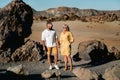 A couple, a woman and a man in the desert crater of the Teide volcano and enjoy the sunset view. Travel to the mountains, freedom Royalty Free Stock Photo