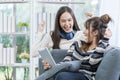 Couple women rejoicing. Two Young Woman Talking and rejoicing. Two women use tablets on the sofa in the living room Royalty Free Stock Photo