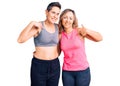 Couple of women wearing sportswear looking confident with smile on face, pointing oneself with fingers proud and happy