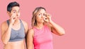 Couple of women wearing sportswear mouth and lips shut as zip with fingers Royalty Free Stock Photo