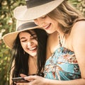 Couple of women young friends have fun together using cellular phone connection in outdoor - concept of girlfriend and lesbian