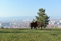 Couple on wooden bench and panoramic view of the town of Leskovac