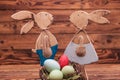 Couple of wooden easter bunnies standing near eggs basket Royalty Free Stock Photo