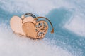 Couple of wooden hearts in cold, frosty morning snow. Valentine`s Day greeting card. Symbol of love and romantic relationships. Royalty Free Stock Photo