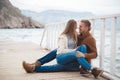 Couple on wooden pier near the sea in autumn Royalty Free Stock Photo