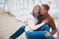 Couple on wooden pier near the sea in autumn Royalty Free Stock Photo