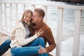 Couple on wooden pier near the sea in autumn Royalty Free Stock Photo