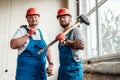 A couple of workers, holding a hammer and a sledgehammer Royalty Free Stock Photo