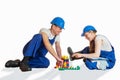 Couple in working outfits and helmets play baby cubes Royalty Free Stock Photo