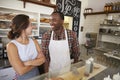 Couple working at a sandwich bar looking at each other Royalty Free Stock Photo