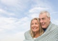 Couple Wrapped In Blanket Looking Away Against Sky Royalty Free Stock Photo