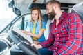 Couple at yard of RV dealer planning the trip with their camper