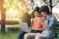 Couple young asian man and woman working with laptop and enjoying cheerful his online winner success  on a bench in the park Royalty Free Stock Photo