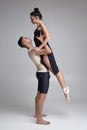 Two athletic modern ballet dancers are posing against a gray studio background. Royalty Free Stock Photo