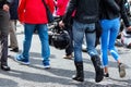 Couple of young bikers with helmets in their arms are hugging along the street. Slim legs of a girl in blue jeans next to a man Royalty Free Stock Photo