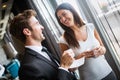 Couple of young colleagues in formal wear standing at workplace, drinking coffee near window Royalty Free Stock Photo