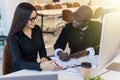 Couple of young designers working at modern office, two coworkers discussing fun project over a laptop, little team of Royalty Free Stock Photo