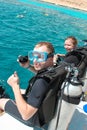 Couple divers preparing to dive from the boat on Summer day. Royalty Free Stock Photo