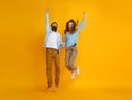 Couple of emotional people man and woman jumping on yellow background Royalty Free Stock Photo