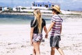 Couple of young girl and boy in tourist leisure activity walking on the beach in love and relationship. Happy people enojy Royalty Free Stock Photo