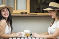 Couple of young and happy caucasian girls have fun together laughing and taking a coffee break at bar outdoor - cheerful females Royalty Free Stock Photo