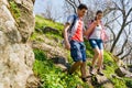 Young Happy Couple Hiking with Backpacks on the Beautiful Rocky Trail at Sunny Evening. Family Travel and Adventure. Royalty Free Stock Photo