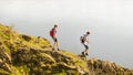 Young Happy Couple Hiking with Backpacks on the Beautiful Rocky Trail at Sunny Evening. Family Travel and Adventure. Royalty Free Stock Photo