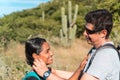 A couple of young hikers with backpacks on the crest of the mountain The couple hugs each other