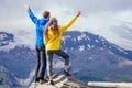 Couple of young hikers in yellow and blue raincoats standing on mountains in Elbrus Royalty Free Stock Photo