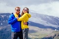 Couple of young hikers in yellow and blue raincoats standing on mountains in Elbrus Royalty Free Stock Photo