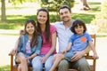 Couple with young kids sitting on park bench Royalty Free Stock Photo