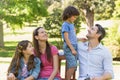 Couple with young kids sitting on park bench Royalty Free Stock Photo