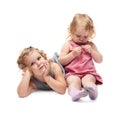 Couple of young little girl sitting over isolated white background Royalty Free Stock Photo