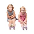 Couple of young little girl sitting over isolated white background Royalty Free Stock Photo