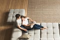 Couple young man and woman at home together, sitting on sofa Royalty Free Stock Photo