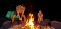 A couple of young people are camping in forest. Man chopping wood for a fire with an axe Royalty Free Stock Photo