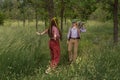 Couple of young people in a hippie style in the forest. A girl is dancing, a guy is carrying a retro tape Royalty Free Stock Photo