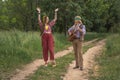 Couple of young people in hippie style. A girl is dancing, a guy is playing a guitar on a country road Royalty Free Stock Photo