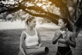 Couple of young sporty woman holding yoga mats and talking together at public park in the morning,Happy and smiling,Relaxing time,