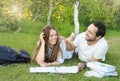 Couple of young students have fun while studying in the park