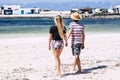 Couple of young tourist walking together barefoot at the sandy beach. Concept of summer holiday vacation people. Boy and girl Royalty Free Stock Photo