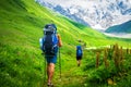 Couple of young travelers hiking with backpacks
