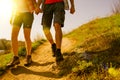 Young Couple Hiking with Backpacks on the Beautiful Rocky Trail at Sunny Evening. Family Travel and Adventure.