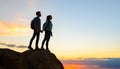 Couple of Young Travelers Standing on the Top of the Rock at Summer Sunset. Family Travel and Adventure Concept Royalty Free Stock Photo