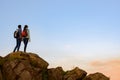 Couple of Young Travelers Standing on the Top of the Rock at Summer Sunset. Family Travel and Adventure Concept Royalty Free Stock Photo