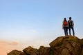 Couple of Young Travelers Standing on the Top of the Rock at Summer Sunset. Family Travel and Adventure Concept Royalty Free Stock Photo