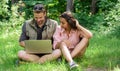 Couple youth spend leisure outdoors with laptop. Modern technologies give opportunity to be online and work in any