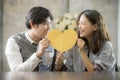 Couples of asian man and woman holding heart shape paper cut with happiness emotion ,people love conceptual