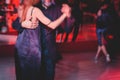 Couples dancing argentinian dance milonga in the ballroom, tango lesson in the red lights, dance festival Royalty Free Stock Photo