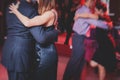 Couples dancing argentinian dance milonga in the ballroom, tango lesson in the red lights, dance festival Royalty Free Stock Photo